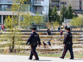 Pictured are two police officers patrolling the pathways in Prince's Island Park and along the Bow River on Wednesday, May 13, 2020.