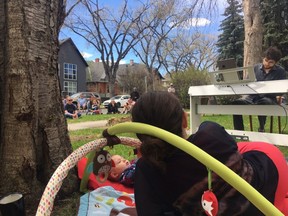 Concert pianist Roman Rabinovich plays a difficult Bach piece during a concert in his front yard while his wife. CPO concertmaster Diana Cohen, and baby look on.