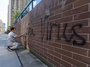 Racist graffiti on the Chinese consulate's wall on 6 Avenue S.W. in Calgary is being cleaned on Wednesday, May 27, 2020.