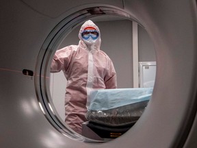 A medical worker wearing protective equipment stands by a computed tomography (CT) scanner at a new hospital built to treat coronavirus patients outside the village of Golokhvastovo, Russia, on April 23, 2020.