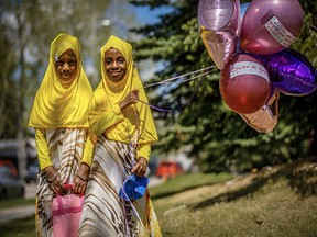 Yasmin, 9, left and her sister Haneen,7, during the drive by Eid at Al-Salam Centre in Calgary on May 24, 2020.