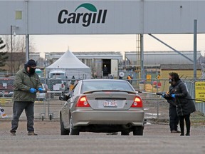 Union members handed out masks and information to workers entering the Cargill plant near High River while protesting the meat processing plant reopening on Monday, May 4, 2020. The plant had been temporarily shut down after hundreds of workers contracted COVID-19. The union says the plant is still not a safe for workers. Gavin Young/Postmedia