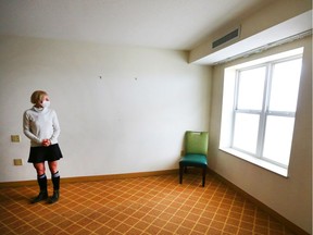 Dr Kerri Treherne looks out a window of a stripped down room at the assisted self isolation hotel in Calgary on Thursday, May 7, 2020. The room is one of the larger rooms in the hotel. It has a large bedroom, bathroom and a kitchenette. The appliances in the kitchentte have been shut off for safety and practicality reasons (clients have food and meds delivered and there is no need to cook or store food). Postmedia has agreed not to reveal the location of the hotel.
