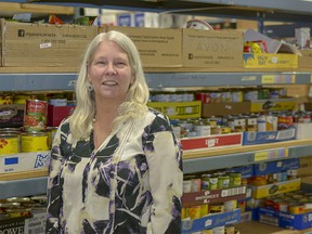 Executive Director Lori McRitchie poses with some of the stockpiled canned goods at the Airdrie Food Bank on Thurs., March 29.