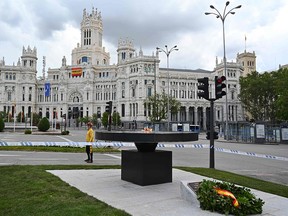 A man walks past a new memorial paying tribute to the victims of the COVID-19 disease at Cibeles Square in Madrid on May 15, 2020.