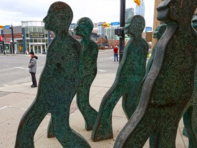 Streets were quiet as usual as a few pedestrians walk past the Starting Fourth statue at the intersection of 4th Street and 17th avenue during the noon hour in Calgary on Tuesday, May 12, 2020. The province may be starting forth on the first stage of reducing COVID-19 restrictions this week.
