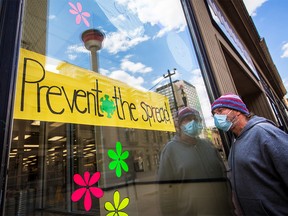 James Caryk looks through the window of the closed Winners clothing store in downtown Calgary on Wednesday, May 13, 2020.