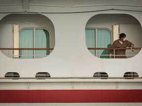 A worker wearing a protective mask cleans a handrail aboard the Carnival Corp. Miracle cruise ship anchored at the Port of Long Beach in Long Beach, California, U.S., on Monday, April 13, 2020.