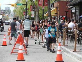 Crowds fill a designated walking area on 17 Ave SW in Calgary on Saturday, May 30, 2020. The City has allowed bars and restaurants to widen patios and making part of the road a pedestrian walkway.