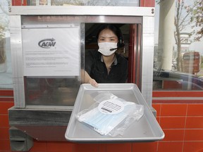 Aiya Hernia at A&W on Macleod Trail in the S.E. poses for a photo as Alberta will distribute 20 million free face masks to residents.