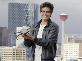 Videographer Eric Gonzalez poses for a photo with his drone in front of the Calgary skyline on Sunday, May 3, 2020. Brendan Miller/Postmedia