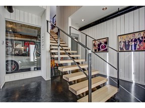 This garage redesign for a Bearspaw home by Woolrich Group includes living spaces that showcase views of vehicles.