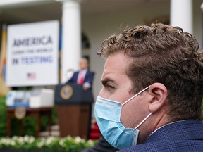 A Trump administration staffer wears a protective face mask in the Rose Garden as U.S. President Donald Trump holds a coronavirus disease (COVID-19) outbreak response briefing at the White House in Washington, U.S., May 11, 2020.