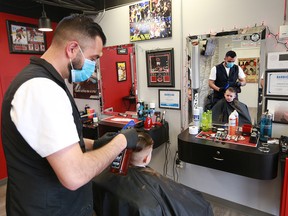 Moe Charanek cuts 12 year-old Cory Flaig's hair at the Six Barbers barbershop in Calgary on Monday, May 25, 2020. After about two months Calgarians can get haircuts again with barbers and stylists operating with COVID-19 precautions.