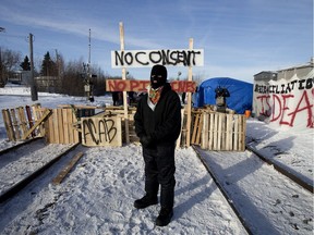 A protester who would only give the name Poundmaker poses for a photo at a blockade set up across the CN rail line near 213 Street and 110 Avenue, in Edmonton Feb. 19, 2020. The protesters had set up the blockade in solidarity with Wet'suwet'en Hereditary Chiefs.