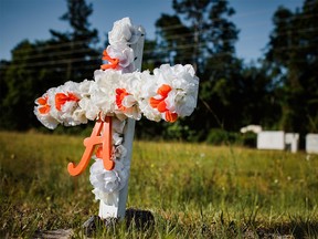 A white and orange cross with an "A" on it stands stuck in the ground along highway 17 at the entrance of the Satilla Shores neighbourhood where Ahmaud Arbery, an unarmed young black man, was shot after being chased by a white former law enforcement officer and his son, at the Glynn County Courthouse in Brunswick, Georgia, U.S., May 8, 2020.