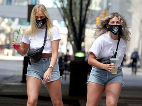 Nina Hill and Ayla Weemaels are seen roller skating along Stephen Avenue during the COVID-19 pandemic in Calgary. A plan spearheaded by Downtown Calgary will allow extensions to patios for restaurants, bars and cafes into the sidewalk area. Wednesday, May 27, 2020. Brendan Miller/Postmedia