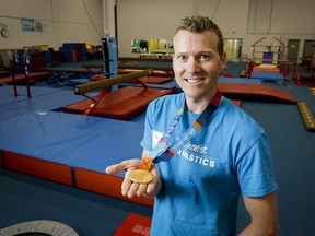 Kyle Shewfelt shows his Olympic gold medal at his gymnastics facility in southeast Calgary, Alta., on Thursday, Aug. 21, 2014.