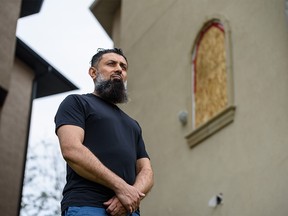 Khalil Karbani, spokesperson for the action committee lobbying the government to declare the recent hail storm a natural disaster, poses for a photo in his backyard in the community of Taradale with a window damaged from the storm in the background on Tuesday, June 23, 2020.