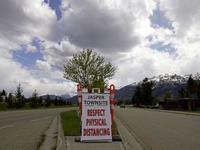 A sign to the entrance of the main street in downtown Jasper reminds visitors of physical distancing requirements during the global COVID-19 pandemic.