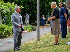 Britain's Prince Charles, Prince of Wales (L), observes social distancing guidelines as he meets front line NHS (National Health Service) key workers who who have responded to the COVID-19 pandemic, during their visit to Gloucestershire Royal Hospital, in Gloucester, western England, on June 16, 2020.