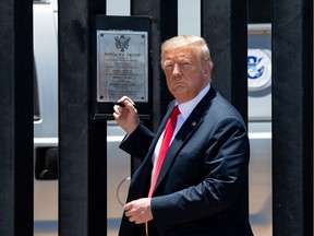 US President Donald Trump looks on before signing a plaque as he participates in a ceremony commemorating the 200th mile of border wall at the international border with Mexico in San Luis, Arizona, June 23, 2020.