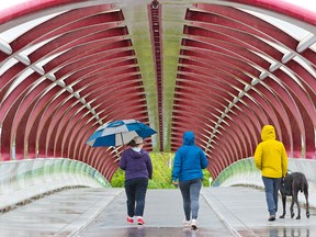 The roof of the Peace Bridge provides some temporary cover from rain for walkers in Calgary on Sunday, June 7, 2020.