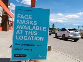Masks are handed out at an A&W drive-through in Calgary on Wednesday, June 10, 2020.