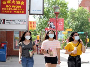 Three woman are seen walking along 2nd Ave. SE while wearing masks in Chinatown. Monday, June 22, 2020.