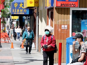 Crowded sidewalks are seen along Centre St. S in Chinatown. Monday, June 22, 2020.