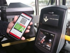 A Transity employee displays Calgary Transit's new My Fare mobile ticketing app and scanner aboard a buss in Calgary on Tuesday, June 30, 2020.  The app will help limit the amount of contact between customers, drivers, and high-touch surfaces.