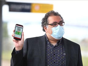 Mayor Naheed Nenshi displays the Calgary Transit's new My Fare mobile ticketing app in Calgary on Tuesday, June 30, 2020.  The app will help limit the amount of contact between customers, drivers, and high-touch surfaces.