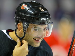 Mark Giordano straps on his helmet during the Flames 2019 training camp in September.