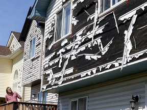 Homeowner Dave Reichert looks over the hail damage to his house and his neighbour's which he looks after in Saddleridge as the province will provide disaster relief funding for uninsurable loss and damage caused by the storm in Calgary on Thursday, June 25, 2020.