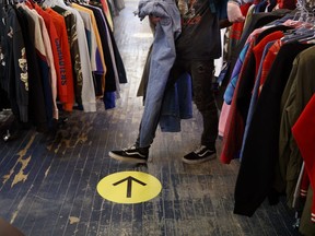 A right of way arrow is seen on the ground in a vintage store on Queen St. West in Toronto, on Tuesday, May 19, 2020.