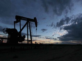 Storm clouds form behind pumpjacks near Acme, northeast of Calgary, on July 19, 2014.