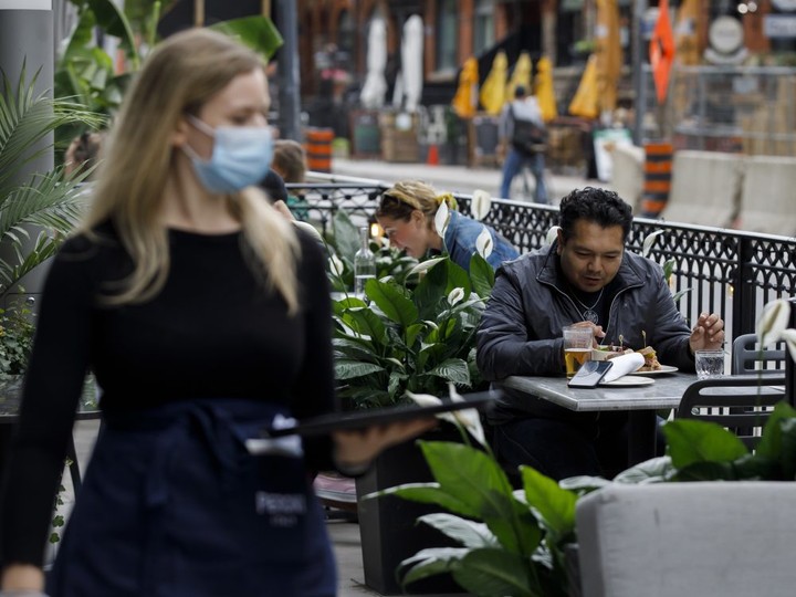  People sit on an outdoor patio in Toronto, on Wednesday, June 24, 2020.