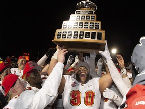 University of Calgary Dinos J-Min Pelley raises the trophy with teammates after winning the Vanier Cup university football championship against the University of Montreal Carabins, in Quebec City on Nov. 23, 2019.