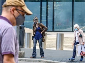People cross the street wearing masks in Downtown Calgary on Monday, July 13, 2020.