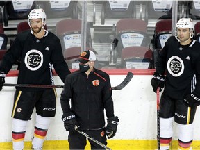 Calgary Flames' T.J. Brodie, left, of Dresden and captain Mark Giordano rest at the boards during the team's first practice since the COVID-19 shutdown Monday at the Scotiabank Saddledome in Calgary. Gavin Young ORG XMIT: POS2007131819146375