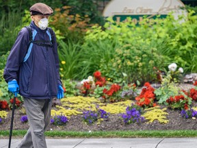 A pedestrian walks outside Eau Claire Park wearing a face mask on Thursday, July 16, 2020.