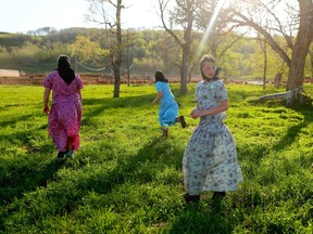 FILE - Young Hutterite girls enjoy a break from branding on the Pincher Creek Colony in southern Alberta on Tuesday May 15, 2018.