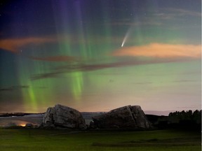 Comet NEOWISE is seen with the glow of the aurora at the glacial erratic near Okotoks on July 14, 2020.