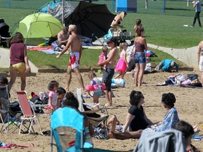 People are seen enjoying the beach at Anniversary Park near Chestermere Lake.