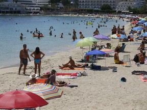 People at the Magaluf beach in Mallorca, Spain as Britons are surprised at Britain's abrupt announcement on Saturday to impose a two-week quarantine on people travelling to the UK from Spain, amid the coronavirus disease.
