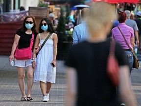 Calgarians wear masks as they walk along Stephen Avenue Mall in downtown Calgary on July 29, 2020. Calgary’s mandatory bylaw on transit and indoor public places began on Aug. 1.