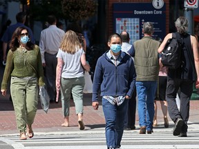 Calgarians wear masks as they walk along Stephen Avenue Mall in downtown Calgary on Wednesday, July 29, 2020. Calgary’s mandatory bylaw on transit and indoor public places begins on Saturday.