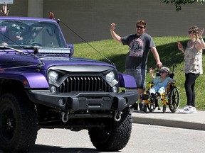 Three-year-old Ben Gauvin is seen waving at a passing Jeep, truck and motorcycle parade in the rear entrance of the Children's Hospital with his parents Dom Gauvin and Rebekah Brooks. Ben is on dialysis and has almost died twice. He needs a kidney transplant. He also loves Jeeps. The Cochrane Jeep Club headed the parade that included several local auto groups and around 70 vehicles. Sunday, July 26, 2020.