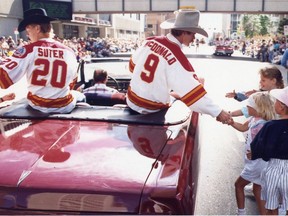 Calgary Flames players Gary Suter and Lanny McDonald shake the hands of  fans on the Calgary Stampede parade route on July 8, 1989, a few weeks after winning the Stanley Cup.  Calgary Herald Archives.