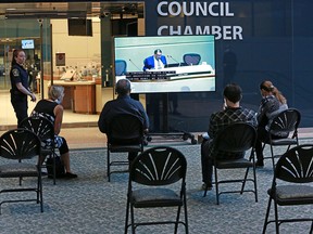 Members of the public watch a Calgary city council session from outside council chambers on Monday, July 20, 2020.